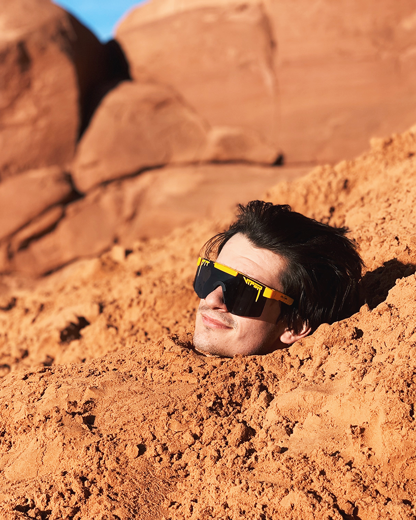 Lifestyle - guy buried in sand pit viper