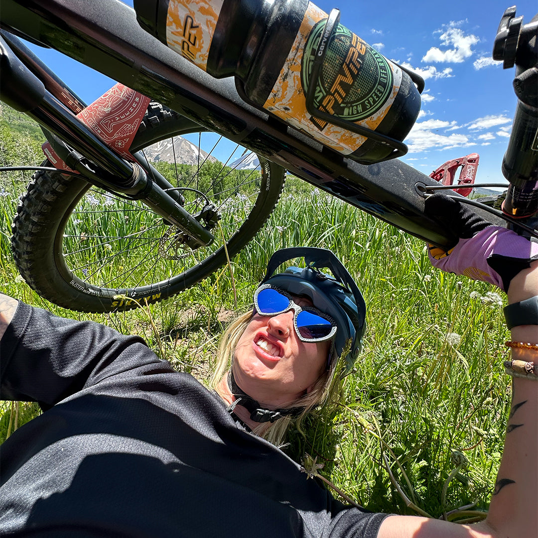 / Blue-Purple | Woman holding a mountain bike wearing The Mangrove Admirer from Pit Viper Sunglasses